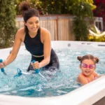 woman exercising on a water bike with a child in a swim spa.