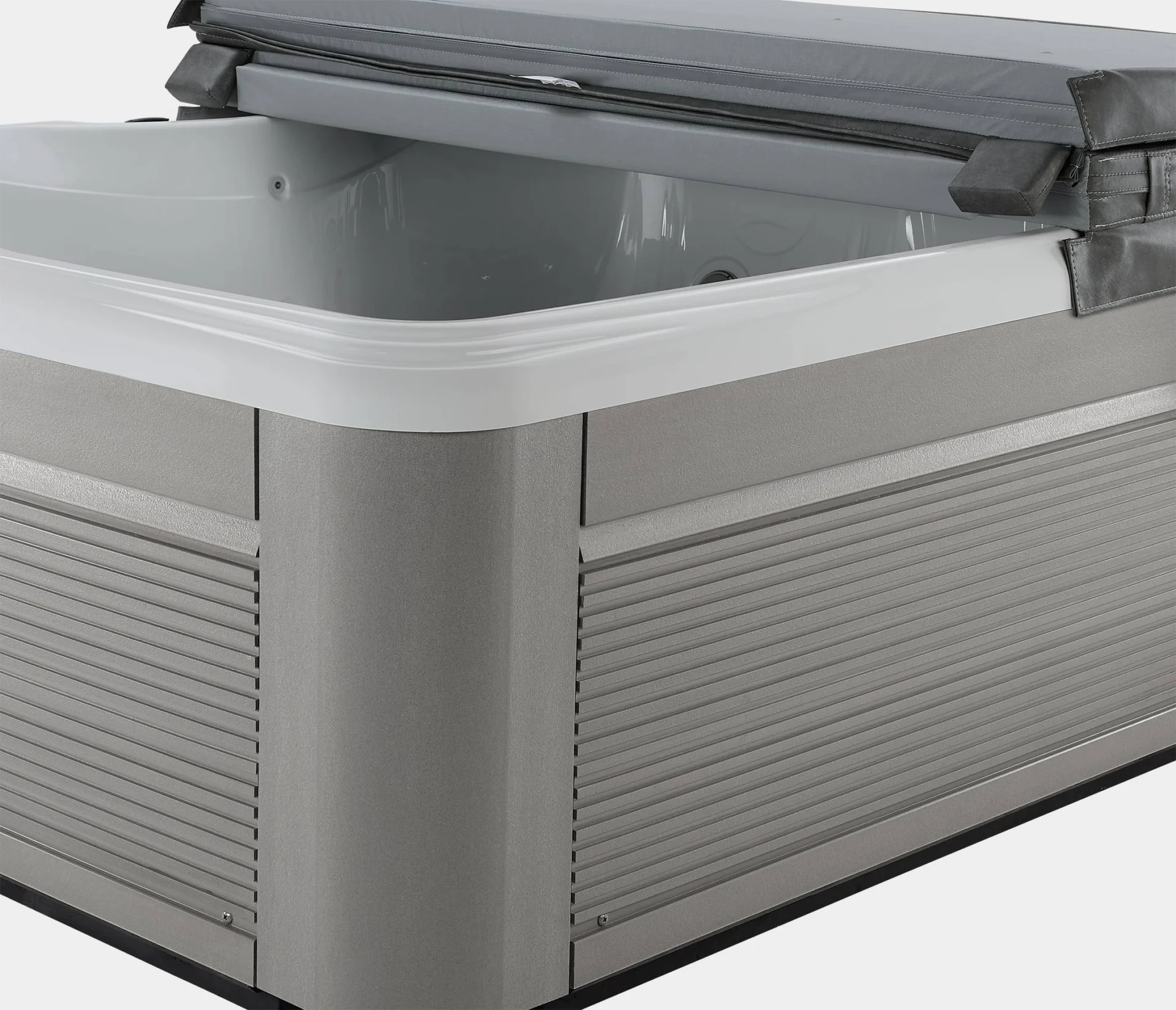 lifestyle outdoor hot tub with gray siding and open cover.