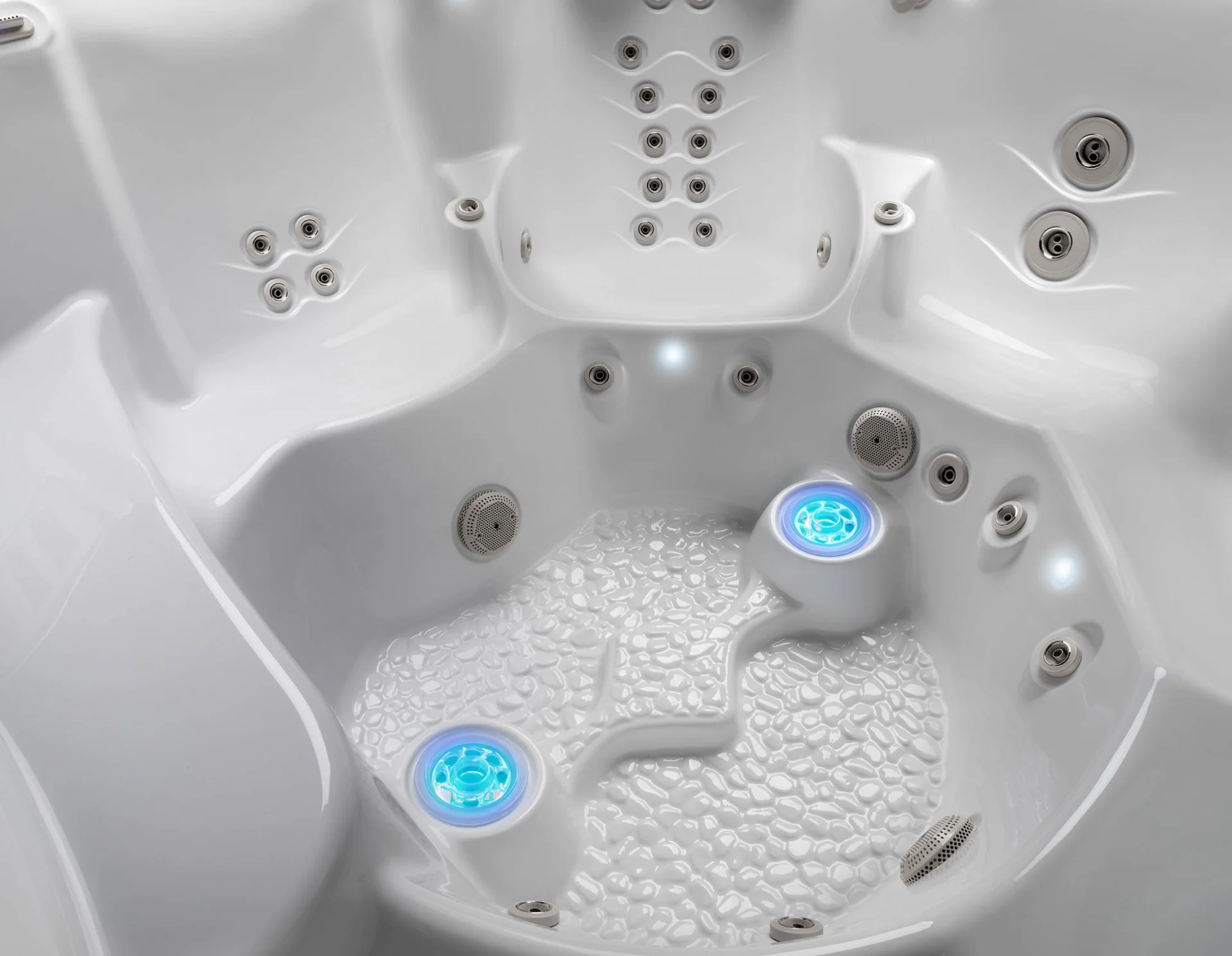 lifestyle outdoor hot tub interior with blue lights and bubbles.