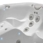 white hot tub interior with multiple jets and blue led lighting.