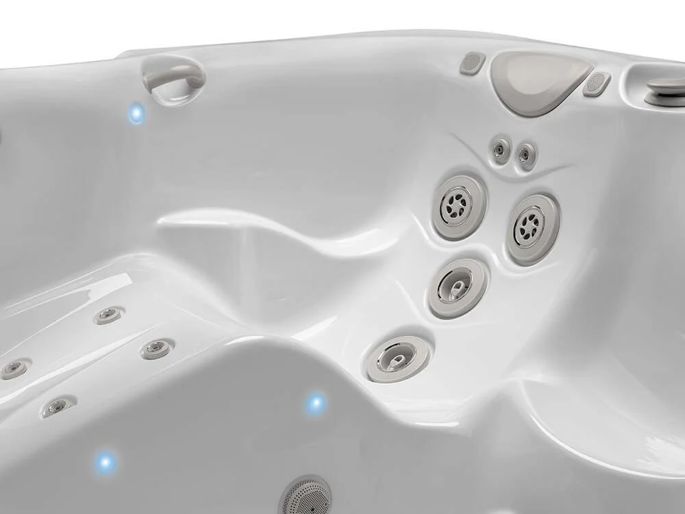 white hot tub interior with multiple jets and blue led lighting.