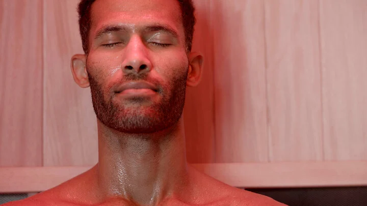 man in an infrared sauna with red light therapy - what does an infrared sauna for for your body?