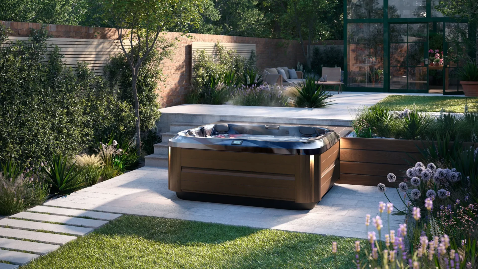 modern square hot tub with dark wood paneling on a light stone patio, surrounded by landscaped garden beds, ornamental grasses, and purple flowering plants.